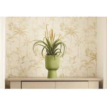 Dekorativní umělá rostlina v žebrovaném květináči na komodě před vzorovanou tapetou