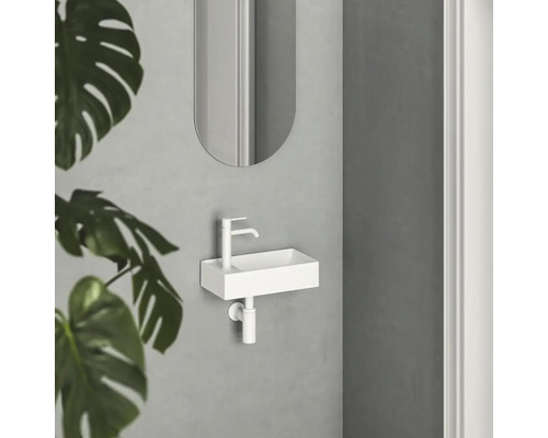 Malé umyvadlo v koupelně se zrcadlem a rostlinou