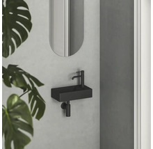 Moderní koupelna s malým obdélníkovým umyvadlem a oválným zrcadlem