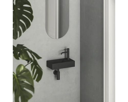 Moderní koupelna s malým obdélníkovým umyvadlem a oválným zrcadlem