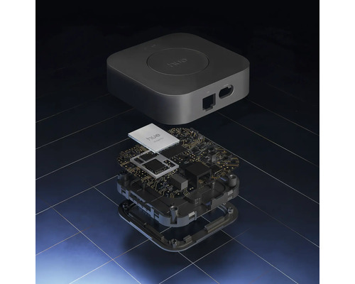 Rozložený pohled na Philips Hue Bridge s krytem a vnitřní deskou plošných spojů s elektronickými součástkami.