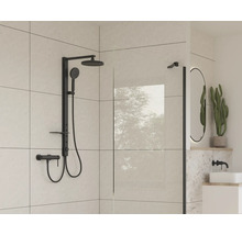 Moderní koupelna s černou sprchovou armaturou a skleněnou stěnou.