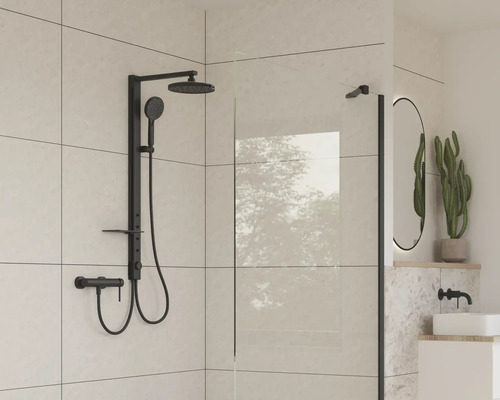 Moderní koupelna s černou sprchovou armaturou a skleněnou stěnou.