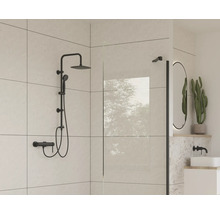 Moderní koupelna s černou sprchovou soupravou, sprchovou zástěnou a oválným zrcadlem