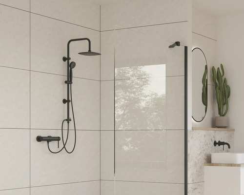 Moderní koupelna s černou sprchovou soupravou, sprchovou zástěnou a oválným zrcadlem