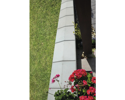 Zákrytová deska ZD 2-20 40x30x8 cm přírodní Detailní záběr zahradního ohraničení z betonových kamenů vedle trávníku a květin