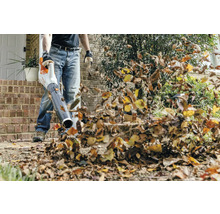 Osoba používá foukač listí k odstranění listí.