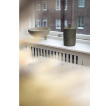 Dekorační mísa a přenosný reproduktor na okenním parapetu