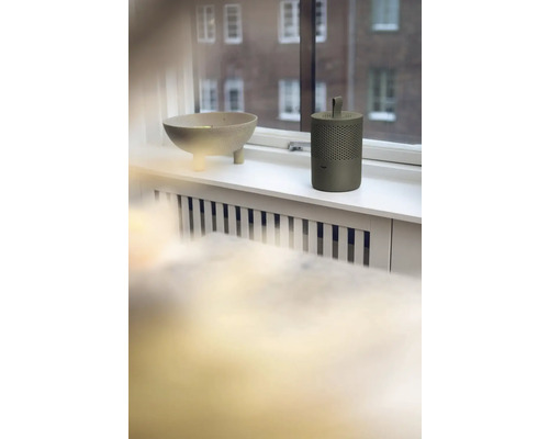 Dekorační mísa a přenosný reproduktor na okenním parapetu