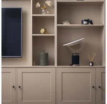 Obývací pokoj s vestavěnou skříní, která obsahuje dekorativní předměty a televizi