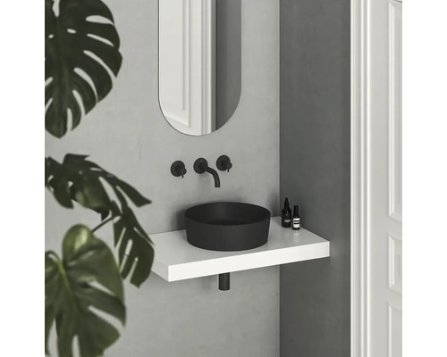 Moderní koupelna s černým umyvadlem na desku, bílou policí a oválným zrcadlem