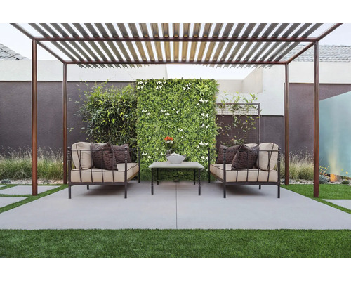 Terasa s pergolou, pohovkami, konferenčním stolkem a stěnou z rostlin pro relaxační venkovní prostor.