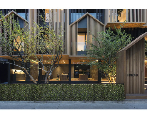 Fasáda moderní budovy s dřevěným obkladem a rostlinami