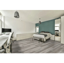 Světlá ložnice s pracovním prostorem, postelí, šedou podlahou a odpovídajícím osvětlením