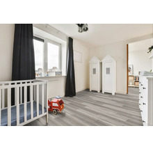 Světlý dětský pokoj s dětskou postýlkou, hračkou hasičským autem a skříněmi ve tvaru domu