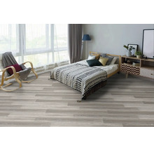 Ložnice s postelí, křeslem a světlou dřevěnou podlahou