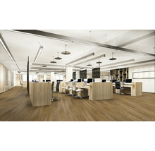 Světlá kancelář typu open space se stoly, kancelářskými židlemi a počítači.