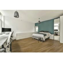 Světlá ložnice s postelí, psacím stolem a lampami