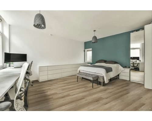 Ložnice s postelí, psacím stolem a dřevěnou podlahou