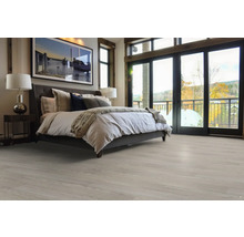 Světlá ložnice s postelí a dřevěnou podlahou