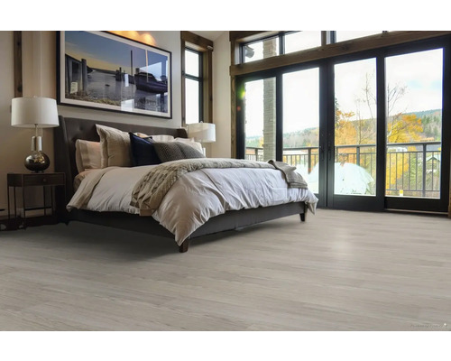 Světlá ložnice s postelí a dřevěnou podlahou