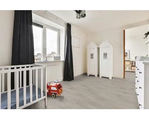 Dětský pokoj s postýlkou, hračkami, oknem a závěsy