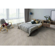 Ložnice se světle dřevěnou podlahou, postelí, nočním stolkem a houpacím křeslem.