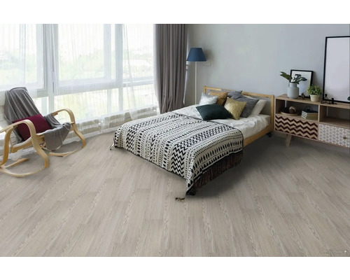 Ložnice se světle dřevěnou podlahou, postelí, nočním stolkem a houpacím křeslem.