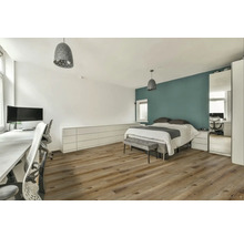 Světlá ložnice s postelí, psacím stolem a dřevěnou podlahou