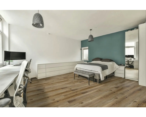 Světlá ložnice s postelí, psacím stolem a dřevěnou podlahou