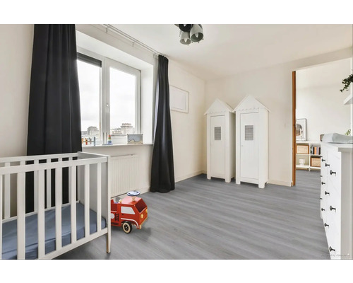 Světle zařízený dětský pokoj s dětskou postýlkou a hračkami