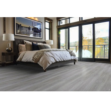 Ložnice s postelí a světlou dřevěnou podlahou