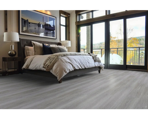 Ložnice s postelí a světlou dřevěnou podlahou