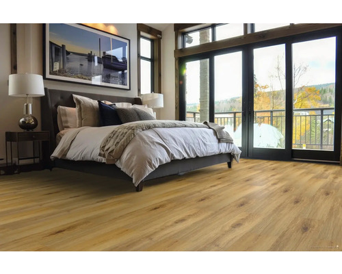 Ložnice s dřevěnou podlahou, postelí, nočním stolkem a okny na balkon