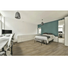 Světlá ložnice s postelí, psacím stolem a odpovídajícím nábytkem.