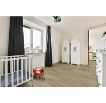 Světly dětský pokoj s dětskou postýlkou, hračkou hasičského auta a dvěma skříněmi ve stylu plážového domu