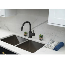 Kuchyňský dřez s vodovodní baterií a dekorativními prvky na pracovní desce.