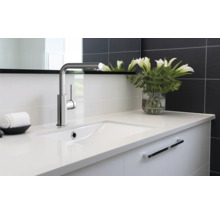 Umyvadlo s baterií a bílými liliemi ve váze