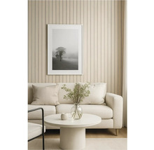 Obývací pokoj s pohovkou, stolem a zarámovaným obrazem stromu