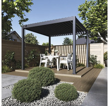 Pergola s lamelovou střechou a jídelní sestavou na terase v zahradě.