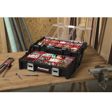 Otevřený černý box Pattfield s průhledným víkem a různými šrouby, hřebíky a hmoždinkami na dřevěném stole.