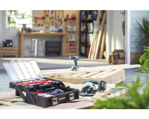 Dílna s kufříkem na nářadí, kotoučovou pilou a vrtačkou na dřevěných trámech