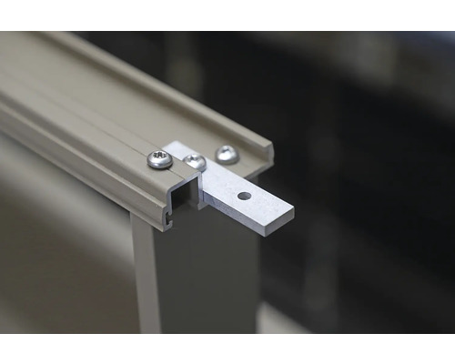 Detailní záběr hliníkové profilové lišty s upevňovací patkou a šrouby