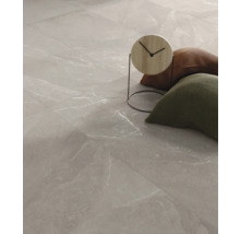 Podlahové dlaždice se vzhledem mramoru a dekorativními předměty.