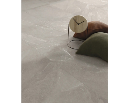 Podlahové dlaždice se vzhledem mramoru a dekorativními předměty.