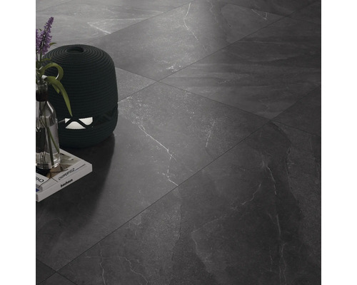 Dlaždicová podlaha s dekorativními předměty a knihami.