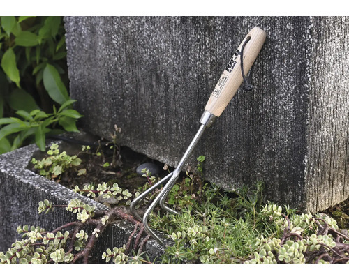 Zahradní nářadí s dřevěnou rukojetí a třemi hroty k prokypření zeminy