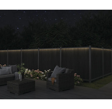 Zahradní nábytek na terase s osvětleným plotem ve tmě
