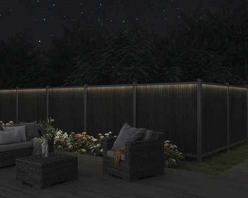 Zahradní nábytek na terase s osvětleným plotem ve tmě
