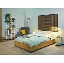 Světlá ložnice s postelí, nočním stolkem, lampou, křeslem a regálem